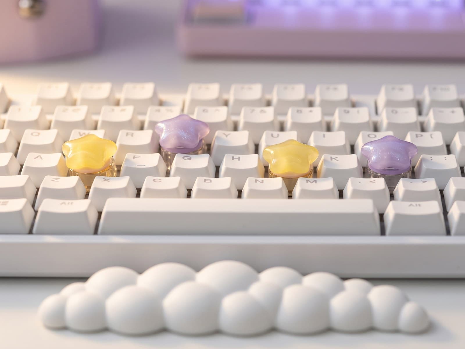 Macro close-up of star-shaped artisan keycaps in yellow and lavender on a white mechanical keyboard